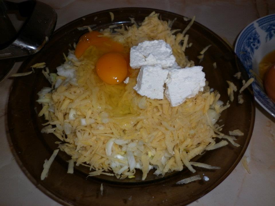 Mixing the cheese and the eggs with the taties